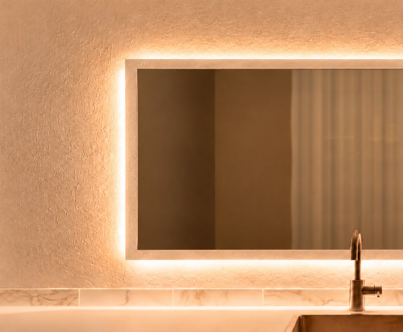 Softly lit mirror and textured wall at the Nurse Victoria clinic, Richmond